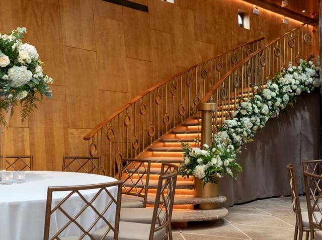 Beautiful flowers adorn the staircase in the Ballroom