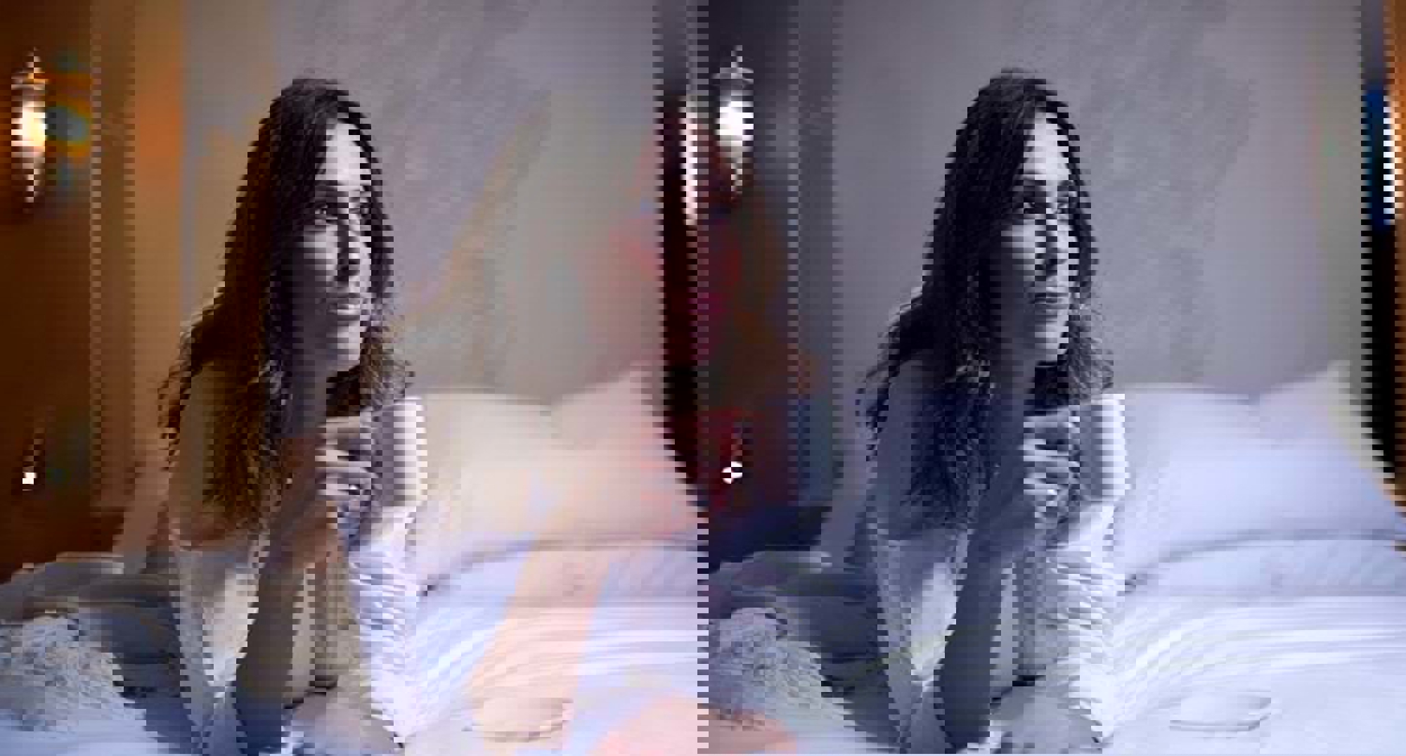 Woman in a white robe laying on a bed.