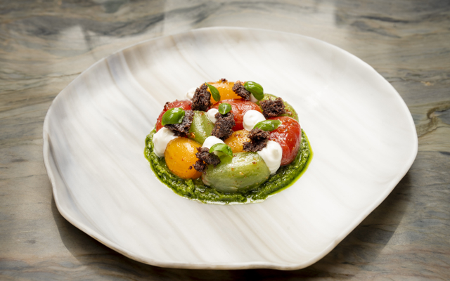 A starter dish Isle of Wight heritage tomato, basil pesto, olive crumb, and crowdie. 
