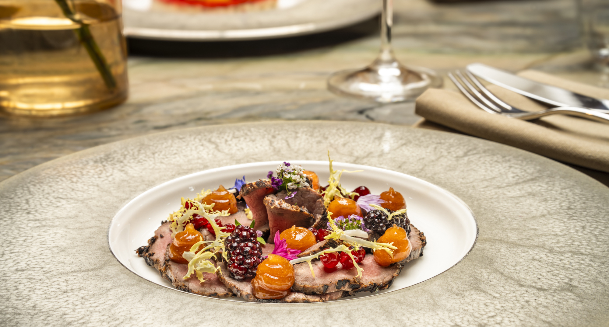 A starter dish of smoked Strathdon red deer salad, lingonberries, sherry blackberries, quince jelly