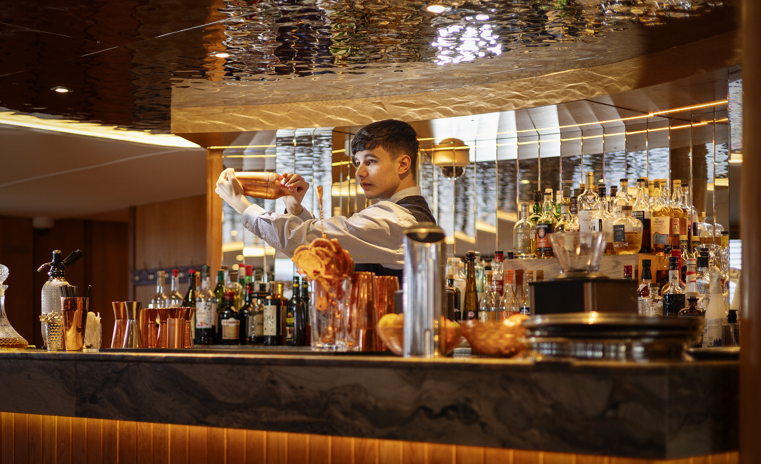 A man making a cocktail behind a bar
