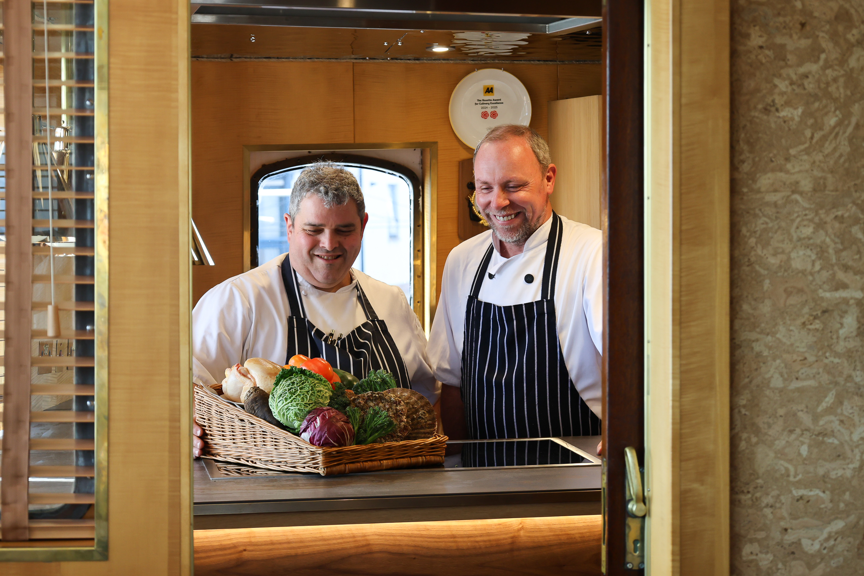 Two chefs preparing fresh vegetables in a ship’s galley.