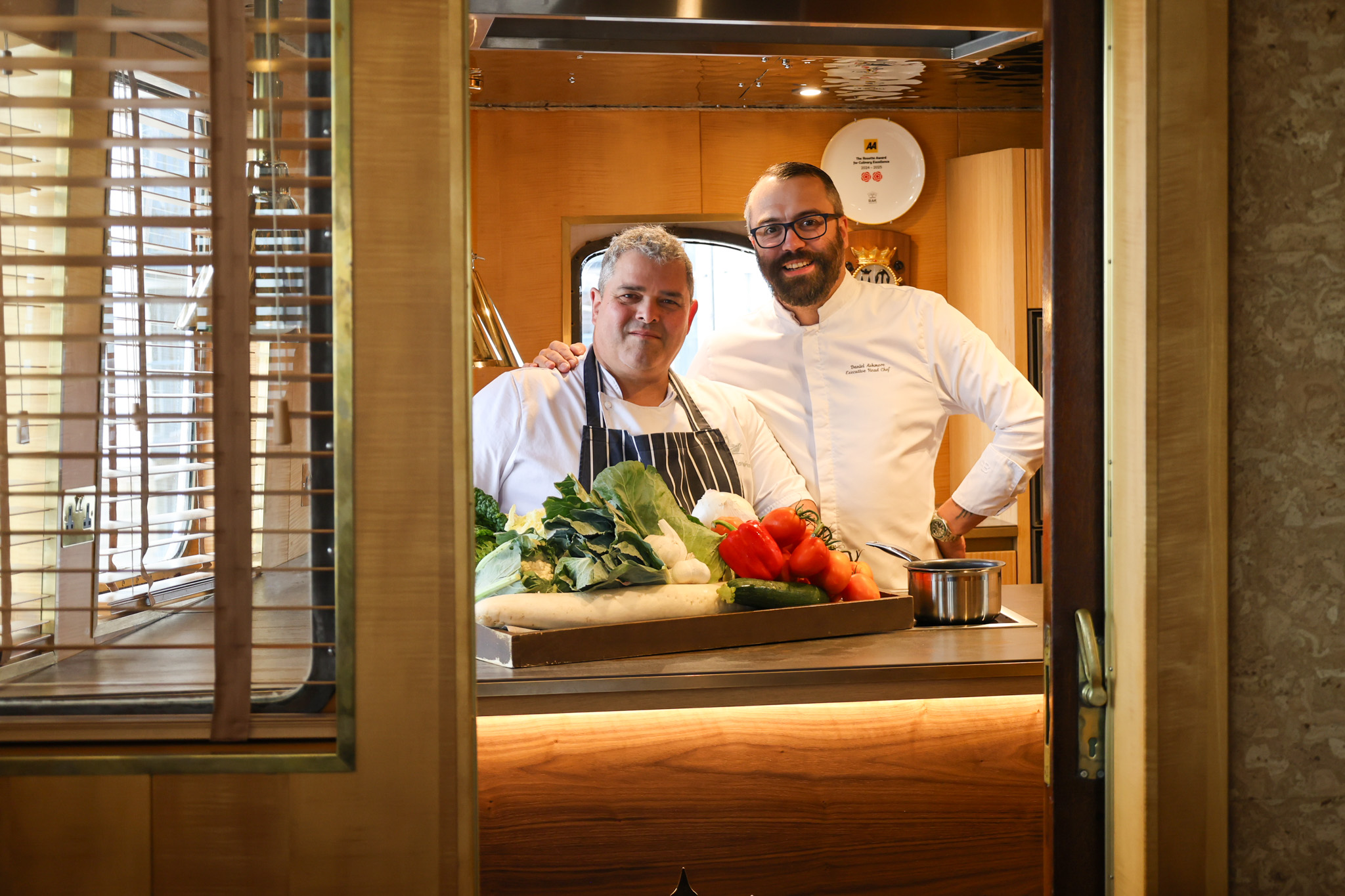 Two Chefs in a Galley Kitchen smiling 