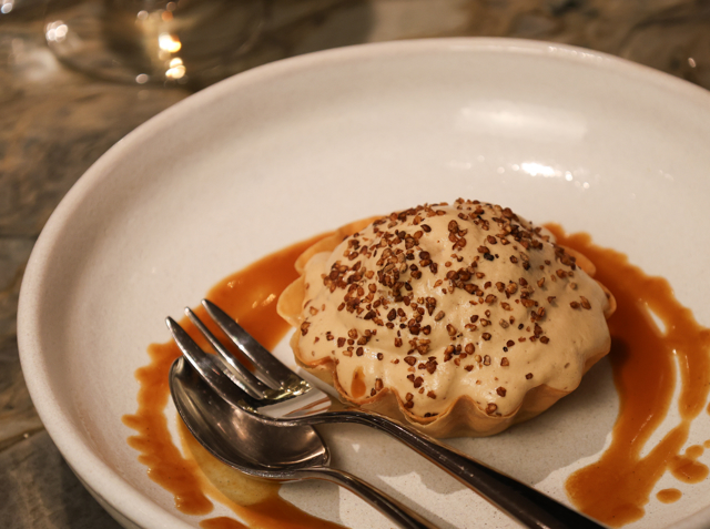 Dessert on a plate with syrup nicely poured around it. 