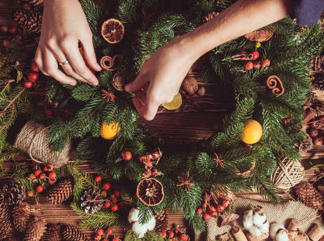 Hands craft a Christmas wreath during a festive wreath-making workshop event in an Edinburgh hotel