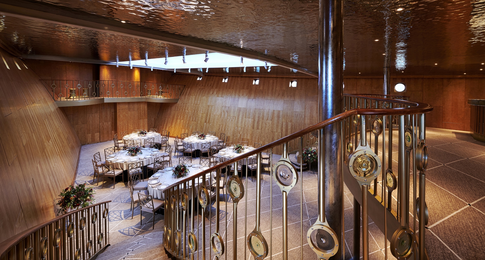 Ballroom looking from the top of a staircase as the stairs cascades down the the right.