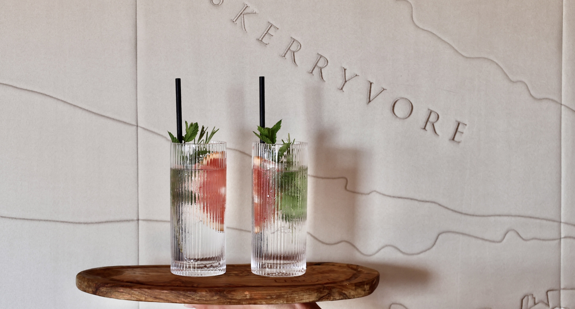 A hand holding the two gin cups.