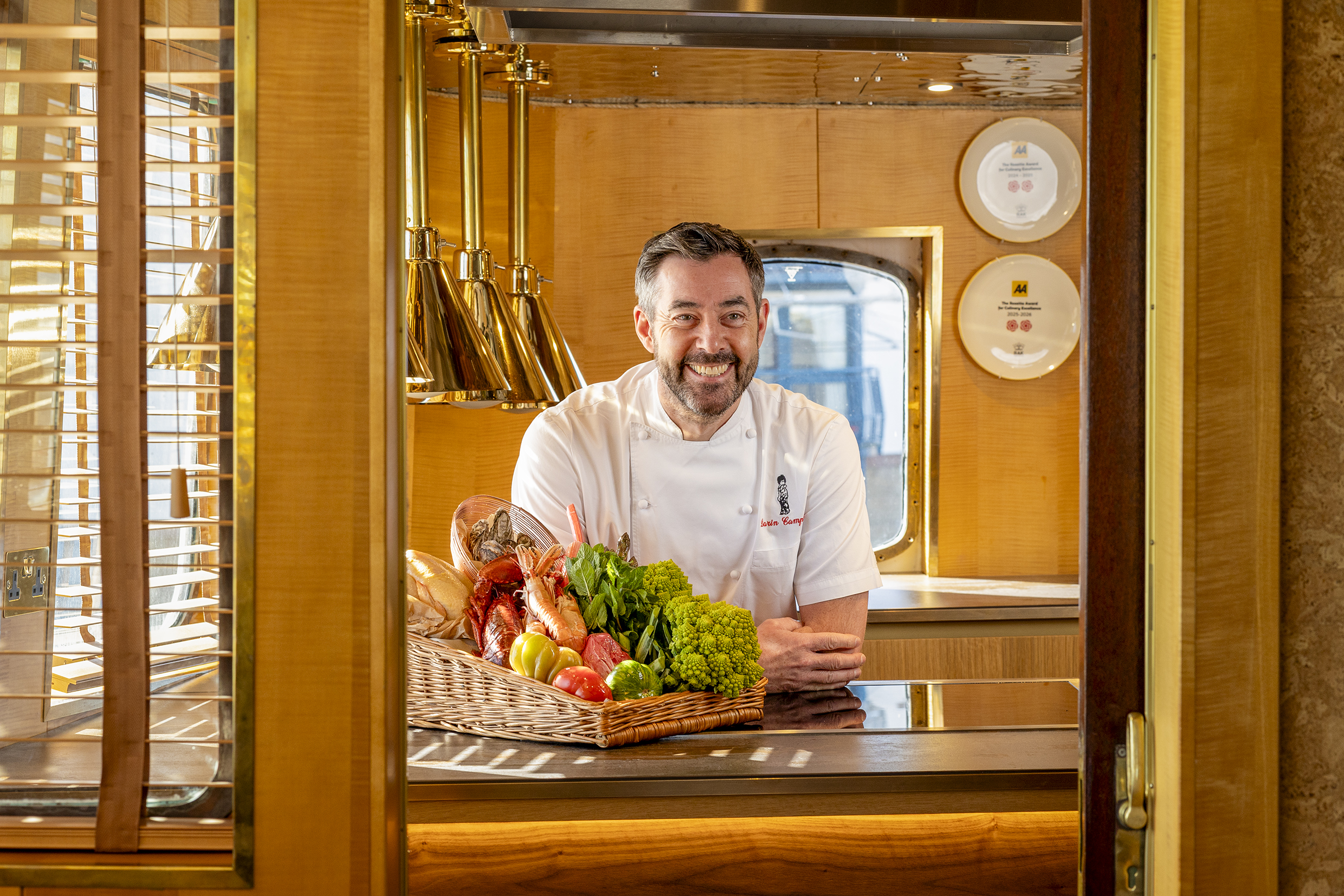 A man in chef uniform leaning over a counter